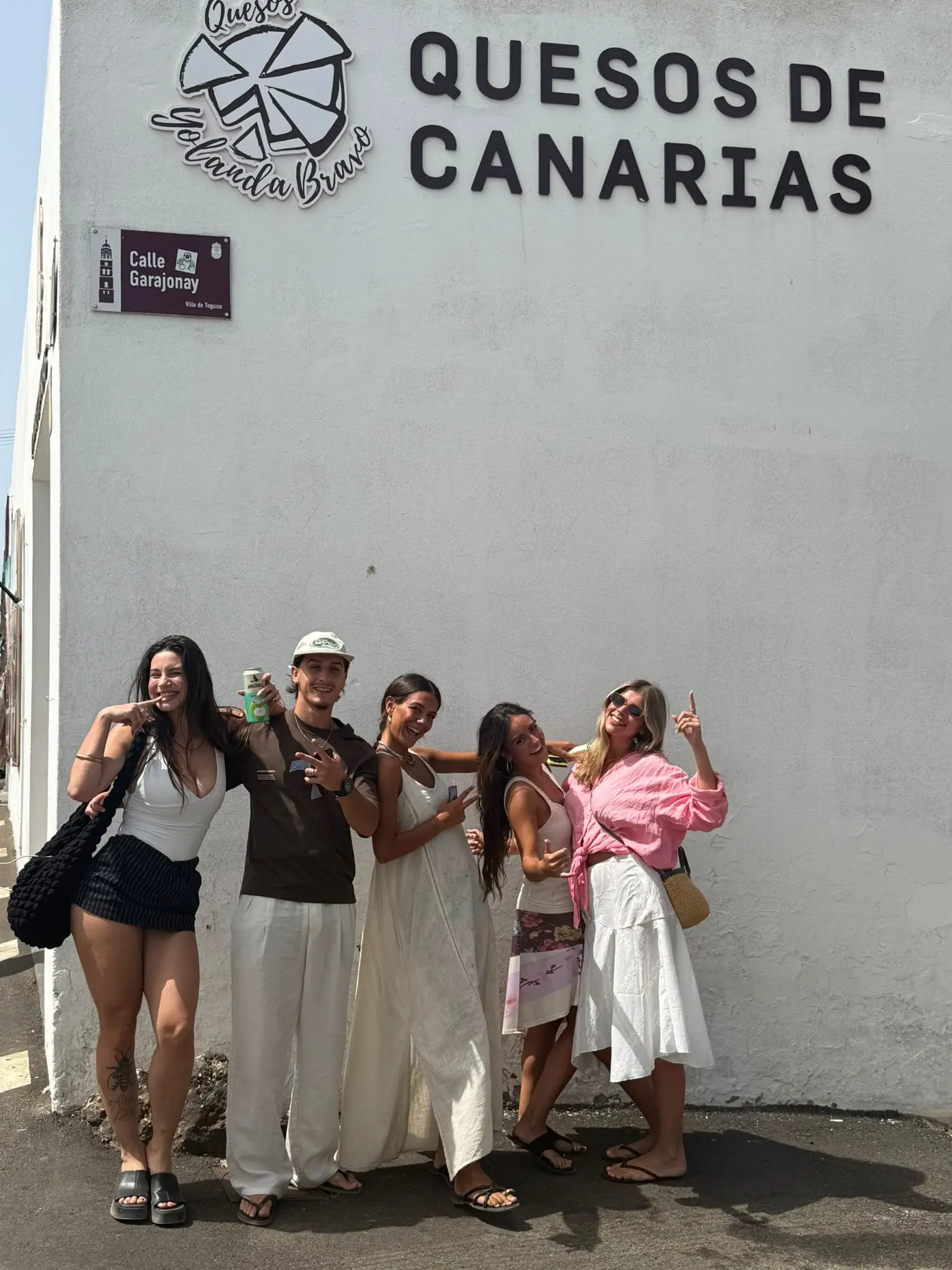 Cinco amigos riéndose y posando frente a una pared blanca en Teguise, Lanzarote